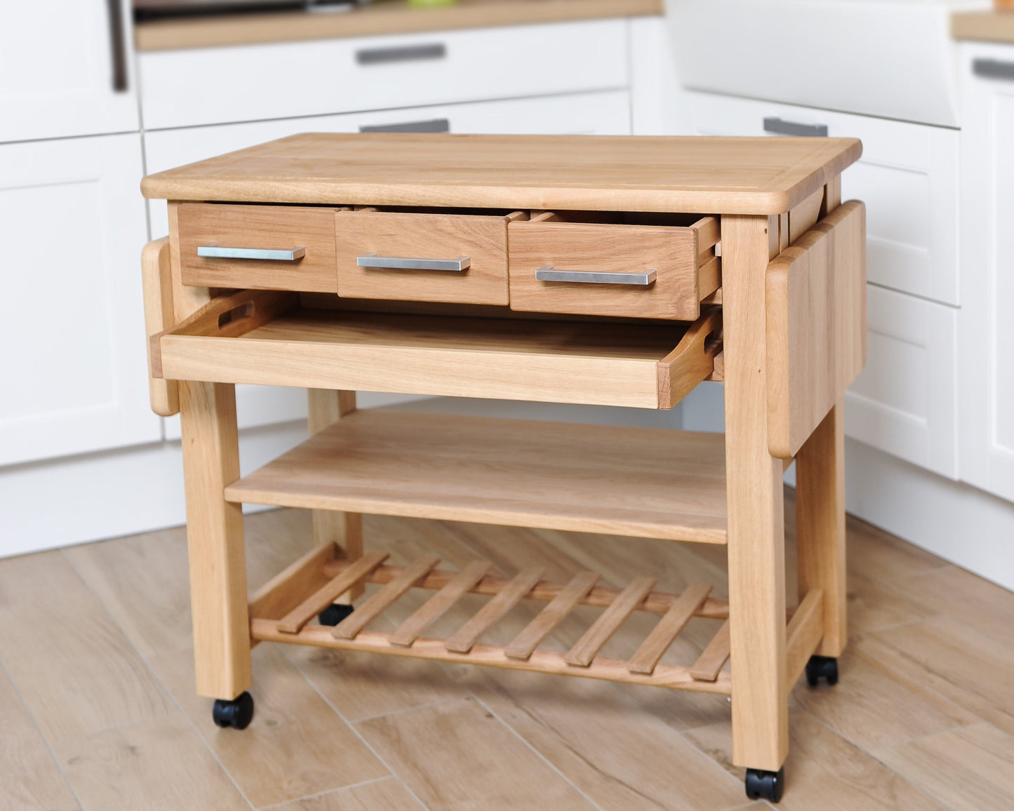 Küchenwagen Mobil 3 aus massiver Eiche. 90 x 50 x 81 cm mit Seitenklappen (Breite x Tiefe x Höhe) mit 3 Schubladen,Tablett, einem Boden und Flaschenablage, Seitenklappen zum ausklappen auf 140cm Breite